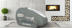 OXYREVO Forward 90 portable hyperbaric chamber in a modern room with a fireplace and plants.